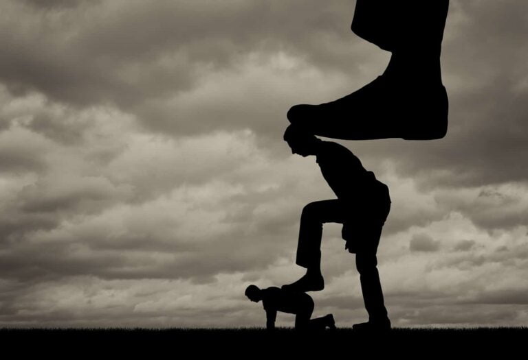 Silhouet van een grote voet die drukt op een man, die op zijn beurt drukt op een andere man op de grond. Het concept van manipulatie en controle over mensen.