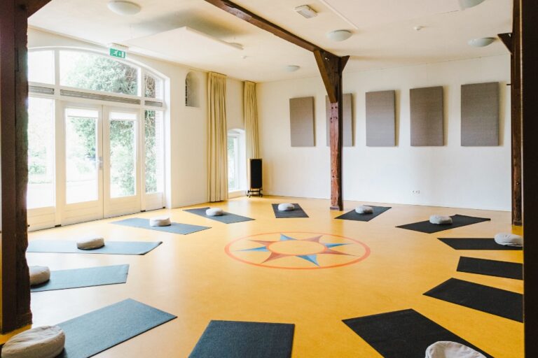 Yogamatjes en meditatiekussens klaar in de zaal van Centrum Athanor