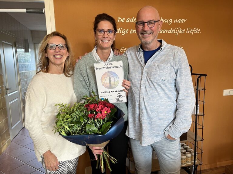 Verse ademcoach met diploma en bloemen, poserend met trainers