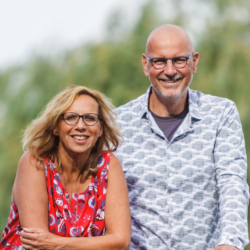 Foto van Marco en Jacquelien, grondleggers van Breathfulness, buiten met groene achtergrond