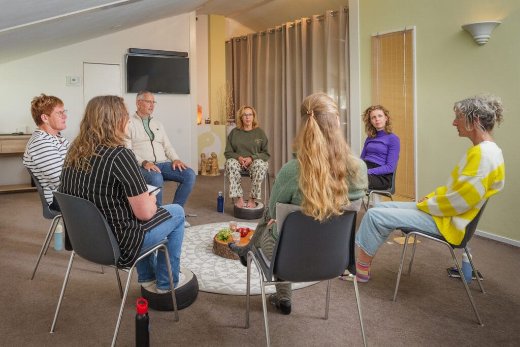 mensen in kring op stoelen delen en luisteren aandachtig