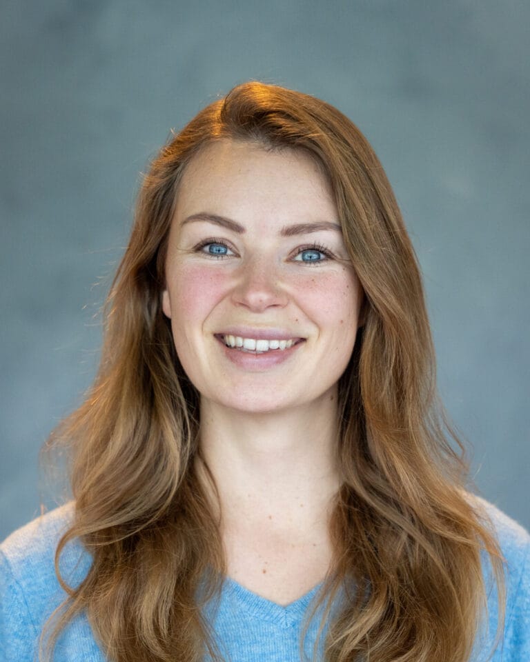 portret nadia pop met blond haar blauwe ogen en blauwe achtergrond